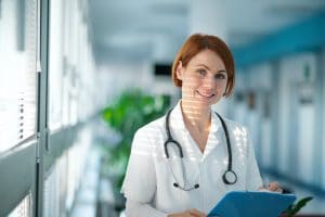 A portrait of woman doctor standing in hospital, looking at camera.