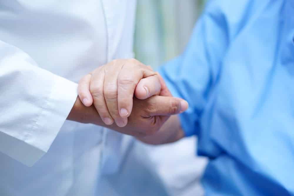 Primary Care Physician holding the hand of a patient