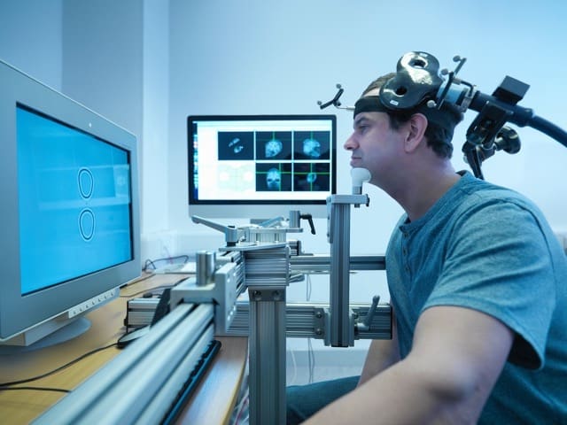 Patient in transcranial magnetic stimulation (TMS) treatment.