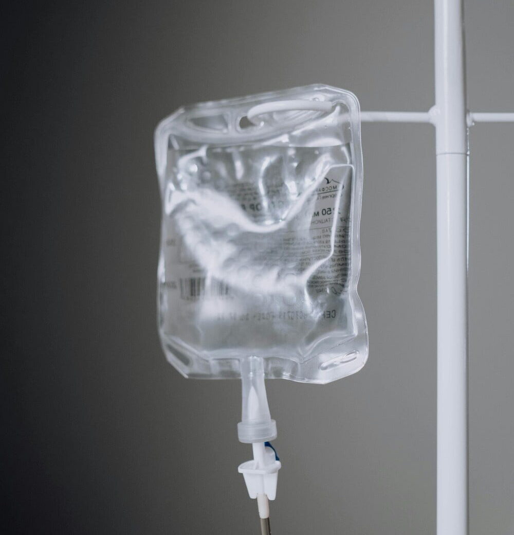 Close-up Photo of an IV Fluid Hanging on Pole